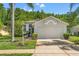 Traditional home with a manicured lawn, mature landscaping, and a well-maintained exterior with a wide driveway at 1013 Sweet Jasmine Dr, Trinity, FL 34655