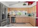 Kitchen featuring wood cabinets, stainless steel appliances, and a view to another room at 1013 Sweet Jasmine Dr, Trinity, FL 34655