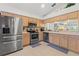 Well-equipped kitchen featuring stainless steel appliances, wood cabinets, and tiled floors at 1013 Sweet Jasmine Dr, Trinity, FL 34655