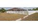 Spacious backyard with a white picket fence surrounding the pool area, and mature trees at 1034 Aladdin Rd, Spring Hill, FL 34609