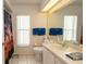 Bright bathroom featuring white cabinets, a sink, and a tropical shower curtain at 1034 Aladdin Rd, Spring Hill, FL 34609