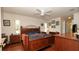 Spacious bedroom features a hardwood floor, fan, large bed, and ample natural light from a large picture window at 1034 Aladdin Rd, Spring Hill, FL 34609