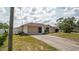 Well-maintained one-story home with attached garage, long driveway, and landscaped front yard at 1034 Aladdin Rd, Spring Hill, FL 34609