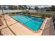 Rectangular pool with clear blue water within a screened enclosure, offering a refreshing outdoor retreat at 1034 Aladdin Rd, Spring Hill, FL 34609
