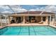 Backyard pool with chairs, grill, outdoor seating, and patio surrounded by a screened enclosure at 1034 Aladdin Rd, Spring Hill, FL 34609