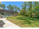 Large backyard with lush greenery and a screened-in pool area, perfect for outdoor enjoyment at 10540 Noddy Tern Rd, Weeki Wachee, FL 34613
