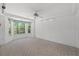 Bedroom with large bay window, ceiling fan, and neutral carpet at 10540 Noddy Tern Rd, Weeki Wachee, FL 34613