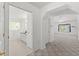 Hallway view with neutral carpet, white walls, and access to bathroom and living room at 10540 Noddy Tern Rd, Weeki Wachee, FL 34613