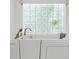 Close-up of a soaker tub with glass block window and gold faucet in the main bathroom at 10540 Noddy Tern Rd, Weeki Wachee, FL 34613