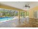 Covered patio with tile flooring, ceiling fan and screened-in pool view at 10540 Noddy Tern Rd, Weeki Wachee, FL 34613