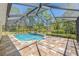 Beautiful screened in-ground pool with unique waterfall feature and adjacent tiled patio at 10540 Noddy Tern Rd, Weeki Wachee, FL 34613