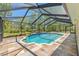 Large in-ground pool with screened enclosure and tiled patio deck at 10540 Noddy Tern Rd, Weeki Wachee, FL 34613