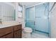 Bathroom showcases a glass-enclosed shower, floral wallpaper, and tiled flooring at 10641 Timber Ln, Port Richey, FL 34668