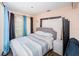Comfortable bedroom features a large window, neutral tones, and stylish striped bedding at 10641 Timber Ln, Port Richey, FL 34668