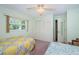 Cozy bedroom with two beds, pastel-green walls, natural light, and ample closet space at 10641 Timber Ln, Port Richey, FL 34668
