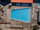 An aerial close-up shot showcases a pool surrounded by lounge chairs and tables, ready for relaxation at 10641 Timber Ln, Port Richey, FL 34668