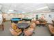 Bright community game room featuring billiard tables, poker tables, and comfortable seating for residents at 10641 Timber Ln, Port Richey, FL 34668