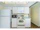Bright kitchen features white appliances, countertops, and ample cabinet space at 10641 Timber Ln, Port Richey, FL 34668