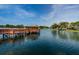 Scenic lake view with a charming wooden gazebo on a pier and a decorative fountain at 10641 Timber Ln, Port Richey, FL 34668