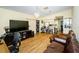 Open-concept living room featuring hardwood floors, a kitchen, and comfortable brown leather seating at 10641 Timber Ln, Port Richey, FL 34668