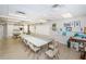 Bright meeting room with multiple tables, seating, artwork, and kitchenette area at 10641 Timber Ln, Port Richey, FL 34668