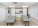 Well-lit meeting room featuring tables, seating, kitchenette area, and exterior access at 10641 Timber Ln, Port Richey, FL 34668