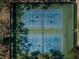 Aerial view of community tennis courts surrounded by mature trees provide shade for tennis matches at 10641 Timber Ln, Port Richey, FL 34668