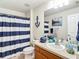 Nautical-themed bathroom with a blue and white striped shower curtain at 1082 Nodding Shade Dr, Brooksville, FL 34604