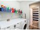 Bright laundry room equipped with a washer, dryer, and storage shelves next to a bathroom at 1082 Nodding Shade Dr, Brooksville, FL 34604