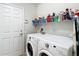Functional laundry room with a washer, dryer, and shelving for storage at 1082 Nodding Shade Dr, Brooksville, FL 34604
