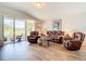 Living room area features a sliding glass door to lanai with leather furniture and modern flooring at 1082 Nodding Shade Dr, Brooksville, FL 34604