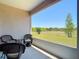 Inviting patio with wicker seating overlooking a green lawn and distant trees under a clear blue sky at 1082 Nodding Shade Dr, Brooksville, FL 34604