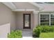 Close-up of the decorative glass front door, complemented by lush landscaping and a welcoming entryway at 11310 Limpkin Rd, Weeki Wachee, FL 34614