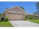 Spacious two-car garage, complemented by a well-manicured lawn and lush landscaping at 11310 Limpkin Rd, Weeki Wachee, FL 34614