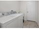 Laundry room with washer, dryer, utility sink, and door to another room at 11310 Limpkin Rd, Weeki Wachee, FL 34614