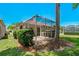 A tranquil backyard featuring a screened-in patio, lush privacy hedges, and mature trees create a relaxing outdoor oasis at 1171 Dartford Dr, Tarpon Springs, FL 34688