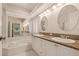 Bright bathroom features double sink vanity with granite countertop, soaking tub, and large mirrors at 1171 Dartford Dr, Tarpon Springs, FL 34688