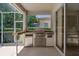 Enjoy grilling in this outdoor kitchen with stainless steel appliances and stone counters on the spacious screened-in lanai at 1171 Dartford Dr, Tarpon Springs, FL 34688