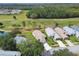 Aerial view of homes in a golf community with landscaping, pond and treeline at 11732 Wheatfield Loop, Hudson, FL 34667