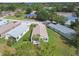 Aerial view of a house with a brown roof, showing a well-manicured lawn and mature trees in a quiet neighborhood at 11732 Wheatfield Loop, Hudson, FL 34667