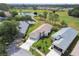 Overhead view of homes in neighborhood with a pond, golf course and tree lined streets at 11732 Wheatfield Loop, Hudson, FL 34667