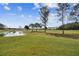 Scenic back yard with pond views, lush grass and mature trees at 11732 Wheatfield Loop, Hudson, FL 34667
