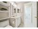 Bathroom featuring white vanity and fixtures, decorative shelving and access to laundry at 11732 Wheatfield Loop, Hudson, FL 34667