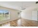 Bedroom with wood-look floors, ceiling fan, and bright windows for ample natural light at 11732 Wheatfield Loop, Hudson, FL 34667
