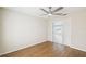 Bedroom with wood floors, ceiling fan and a doorway to a connecting room with plantation shutters at 11732 Wheatfield Loop, Hudson, FL 34667