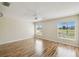 Bright bedroom featuring wood floors, a ceiling fan and two windows with lovely views at 11732 Wheatfield Loop, Hudson, FL 34667