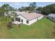 Aerial view of the back exterior with a screened-in lanai surrounded by an expansive lawn and manicured landscaping at 11732 Wheatfield Loop, Hudson, FL 34667