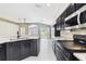 Bright kitchen featuring black cabinets, granite countertops, stainless appliances, and tile floors at 11732 Wheatfield Loop, Hudson, FL 34667