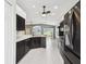 Open-concept kitchen features granite countertops, dark cabinetry, stainless-steel appliances, and bright lighting at 11732 Wheatfield Loop, Hudson, FL 34667