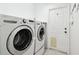 Functional laundry room with side by side washer and dryer and exterior door at 11732 Wheatfield Loop, Hudson, FL 34667
